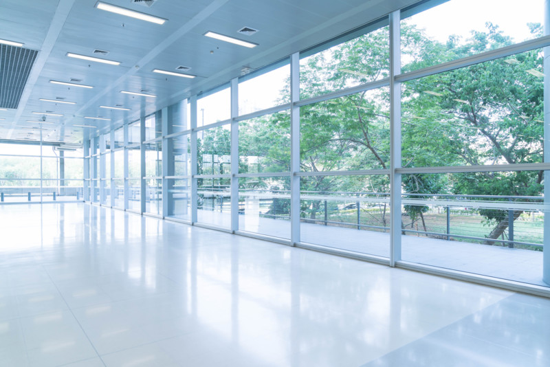 blurred-abstract-background-interior-view-looking-out-toward-empty-office-lobby-entrance-doors-glass-curtain-wall-with-frame (1)